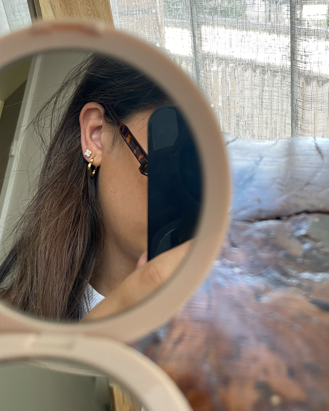 Model mirror shot with clover cubic zirconia dainty flower studs layering with waterproof hoop