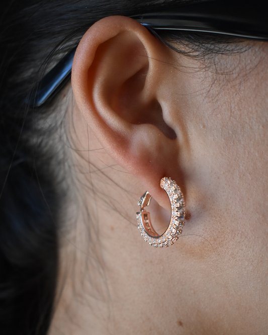 Side view of a woman wearing sparkling rose gold filled hoop earrings with diamonte accents by Sunmul.