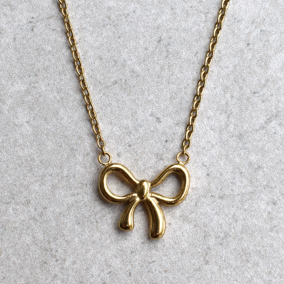 Stainless Steel Bowtiful Necklace. This lovely and trendy piece features a delicate bow ribbon design, plated with stunning 18k gold. Add a touch of sophistication to any outfit with this statement accessory.

Material: Stainless Steel, 18K Gold Filled
Size: Charm - 1.57cm + 1.31cm, Length - 40cm + 4.8cm