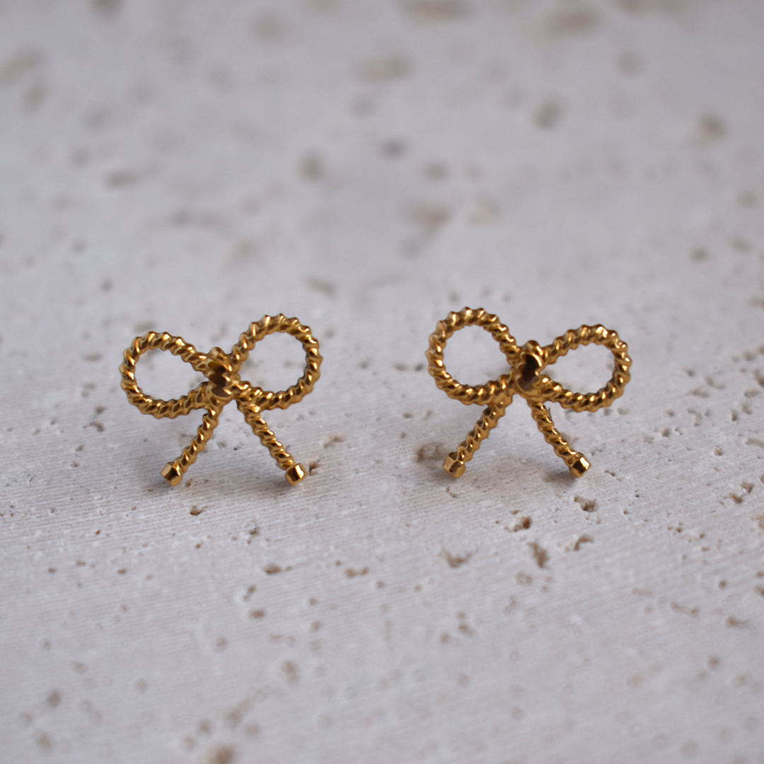 Waterproof Gold Plated Stainless Steel Bowtiful Earrings. Be bold and beautiful with these Bowtiful Earrings! Not only do they have a cute knot design, but they are also waterproof and won't tarnish. Stay stylish without worrying about the weather.

Material: Stainless Steel, 18K Gold Plated
Size: Length - 1cm