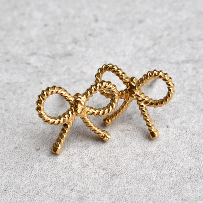 Waterproof Gold Plated Stainless Steel Bowtiful Earrings. Be bold and beautiful with these Bowtiful Earrings! Not only do they have a cute knot design, but they are also waterproof and won't tarnish. Stay stylish without worrying about the weather.

Material: Stainless Steel, 18K Gold Plated
Size: Length - 1cm