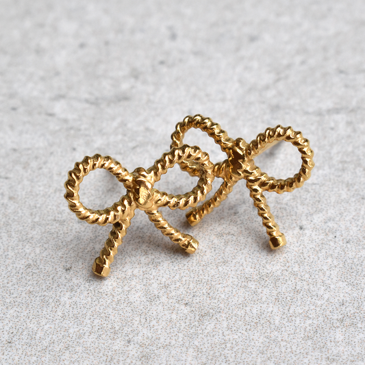 Waterproof Gold Plated Stainless Steel Bowtiful Earrings. Be bold and beautiful with these Bowtiful Earrings! Not only do they have a cute knot design, but they are also waterproof and won't tarnish. Stay stylish without worrying about the weather.

Material: Stainless Steel, 18K Gold Plated
Size: Length - 1cm